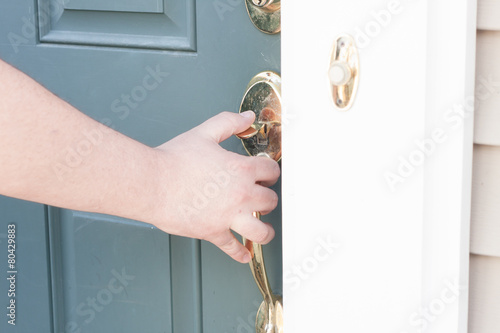 man's hand opening front door photo