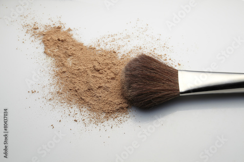 Makeup Brush with beige loose Face Powder on white background