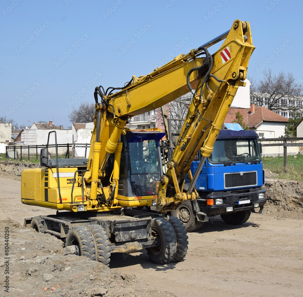 Excavator and a truck at the road construction Excavator and a truck at the road construction