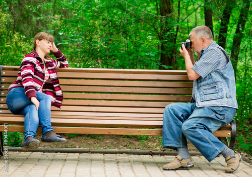 old man photographs the girl in the park