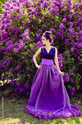 Beautiful girl in lilac ball dress in the garden