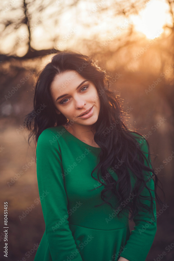 Fototapeta premium portrait of a cute girl in the spring park. sunset