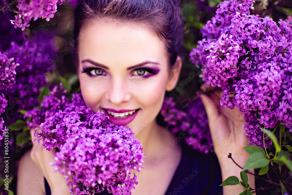 Smiling young girl holding branch of lilac Smiling young girl holding branch of lilac