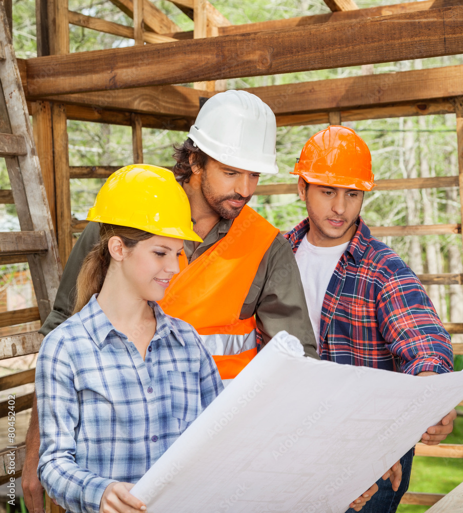 Engineers Examining Blueprint In Wooden Cabin Engineers Examining Blueprint In Wooden Cabin