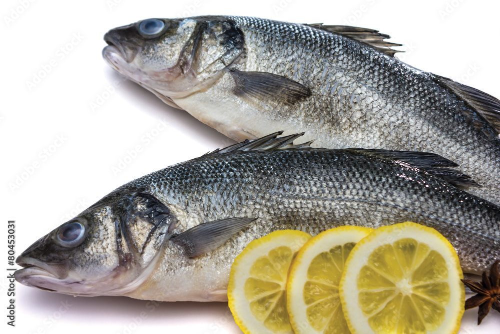 Sea bass fish whit lemon and star anise on withe background Sea bass fish whit lemon and star anise on withe background