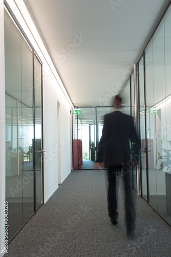 Business man walks in a hallway © larswieser