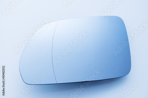 Car side view mirror on clean blue background