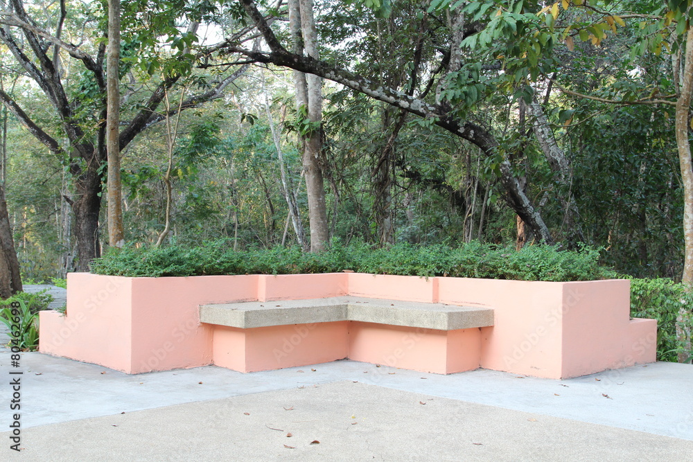 Modern orange concrete bench in garden.