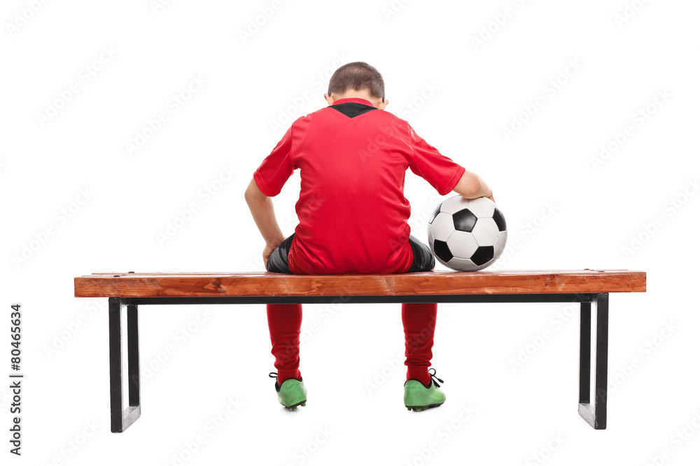 Naklejka premium Rear view of a sad little boy in soccer jersey