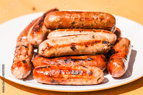 Barbecued beef and pork sausages on white plate