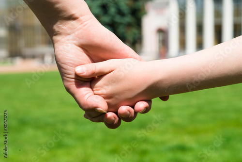 female hand holding a baby in the park © kostyha