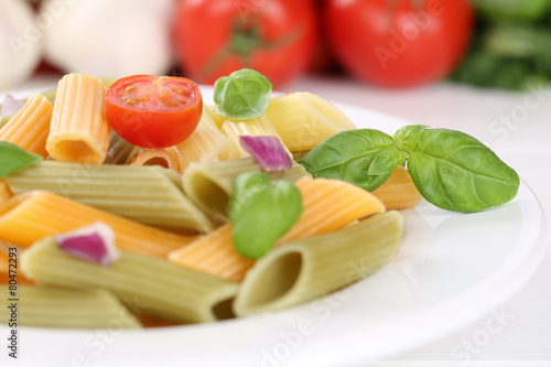 Bunte Penne Rigate Nudeln Pasta mit Tomaten und Basilikum auf Te