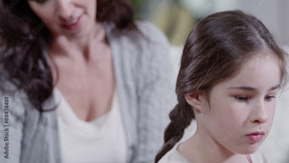 Loving mother plaiting her daughter's hair and gives her a kiss Loving mother plaiting her daughter's hair and gives her a kiss