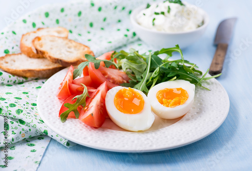 Breakfast with soft-boiled egg, arugula and tomatoes