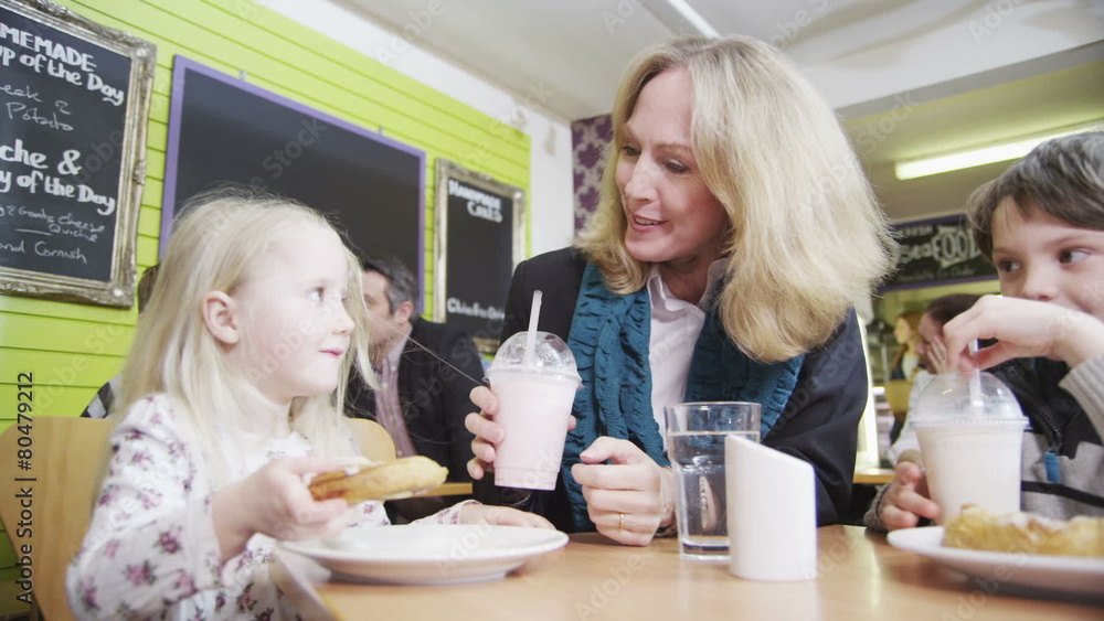 Happy affectionate family enjoying snacks and drinks in a cafe