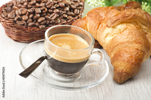 coffee in glass cup with croissants and coffee beans