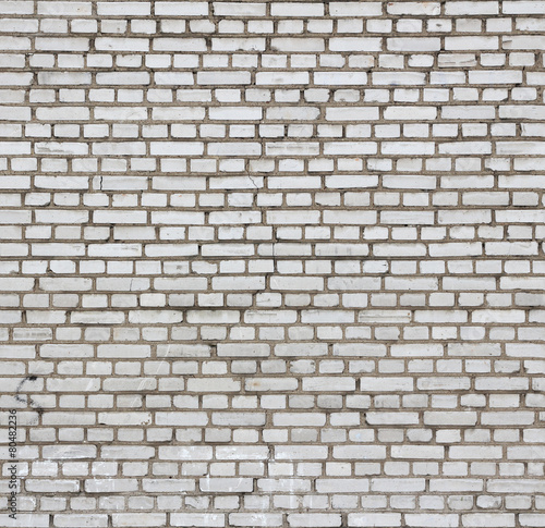 Aged white brick wall seamless texture.