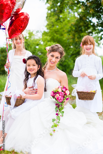 Braut im Brautkleid mit Blumenkindern