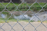 Chainlink fence with stream in background