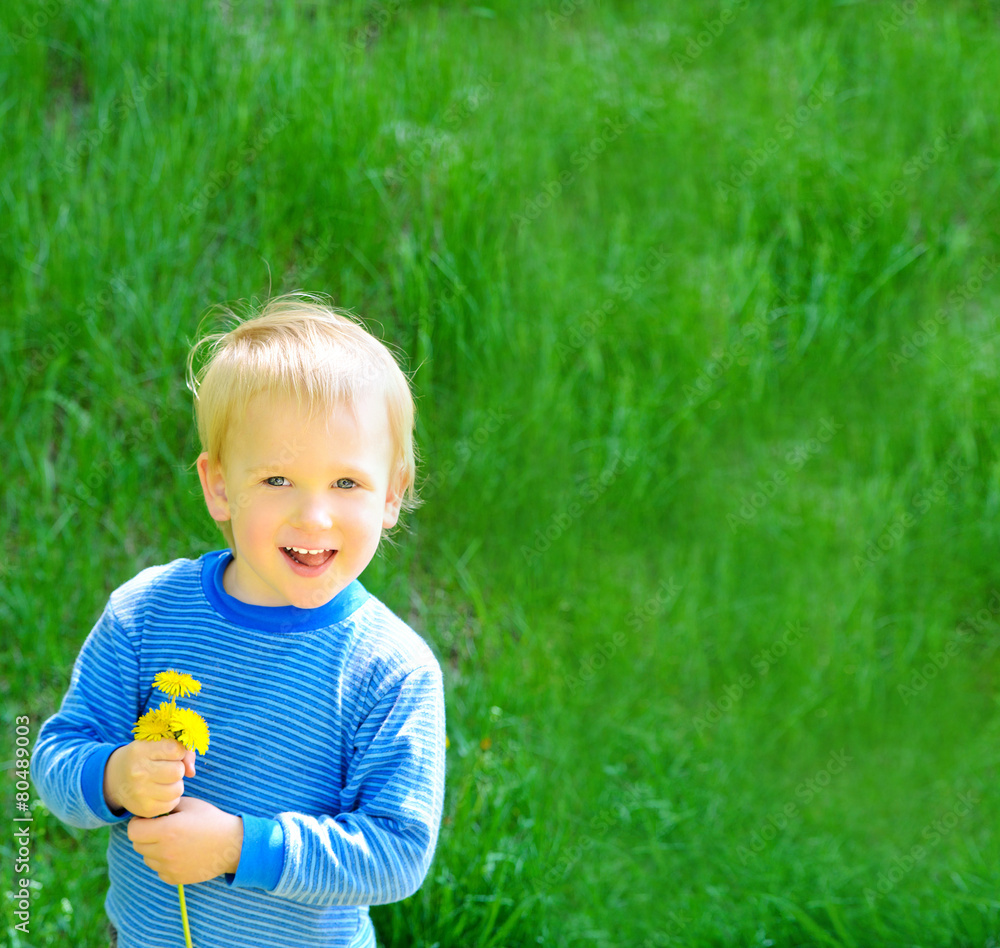 blond boy on spring green grass background blond boy on spring green grass background