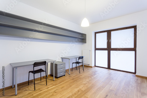 Gray desks in empty interior