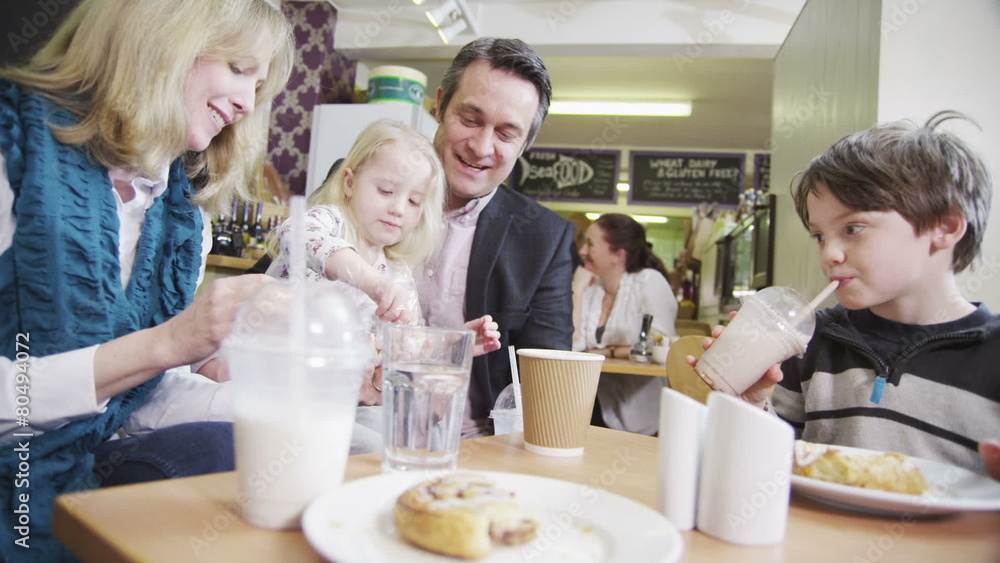 Happy affectionate family enjoying snacks and drinks in a cafe Happy affectionate family enjoying snacks and drinks in a cafe