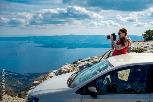 Woman photographer with car on the top of mountain © rh2010