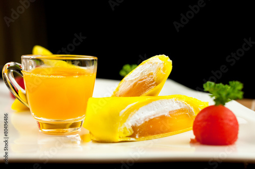 roll pancake mango with mango juice on black background