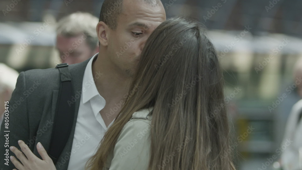 Attractive young couple at a railway station share a kiss and say goodbye Attractive young couple at a railway station share a kiss and say goodbye