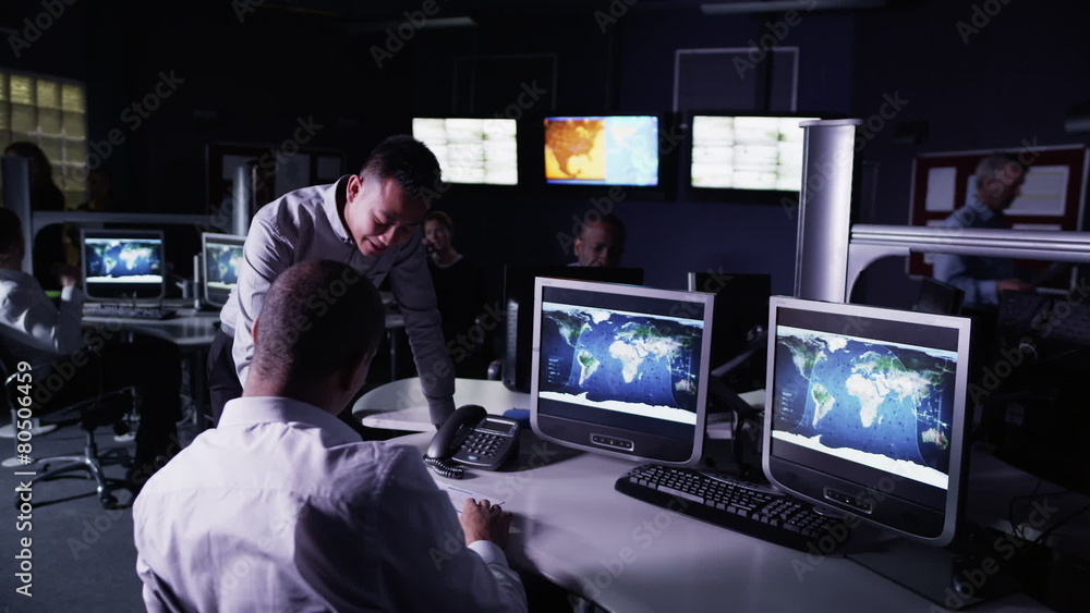Security team watching the screens in control center office Security team watching the screens in control center office