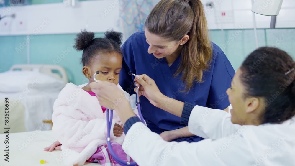 Female doctor uses a stethoscope to examine cute little girl in hospital. Female doctor uses a stethoscope to examine cute little girl in hospital.