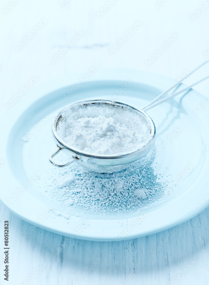 Sieve with icing sugar on a plate Sieve with icing sugar on a plate