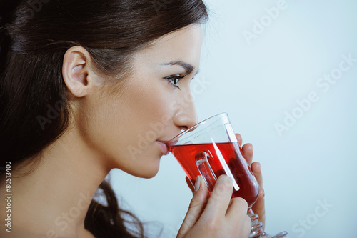 Beautiful woman in red drinking hot herbal tea