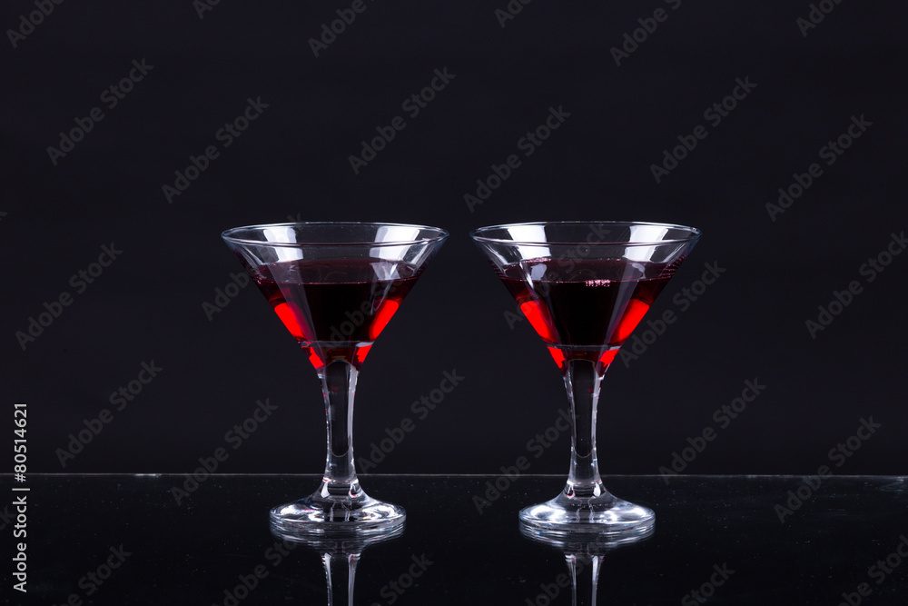 Red wine in a two glasses of martini on a black background Red wine in a two glasses of martini on a black background