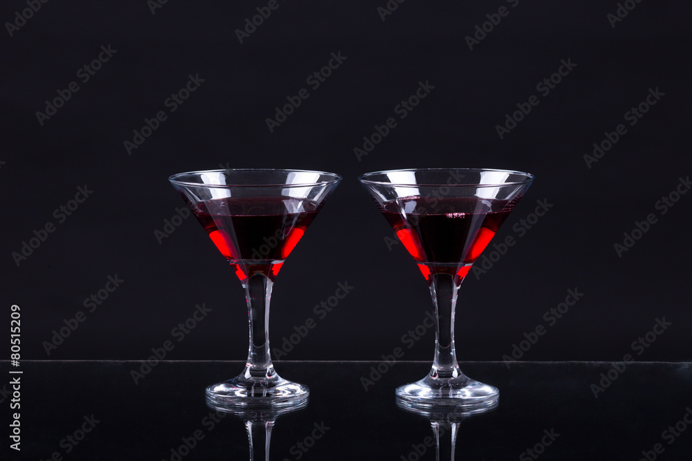 Red wine in a two glasses of martini on a black background Red wine in a two glasses of martini on a black background