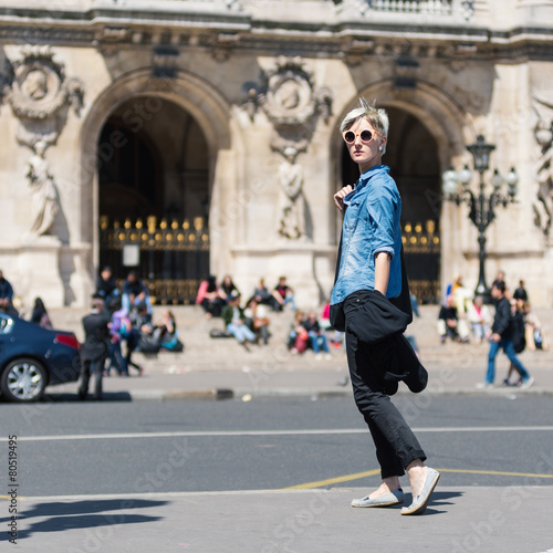 Young blonde woman portrait in front of Opera theater in Paris,