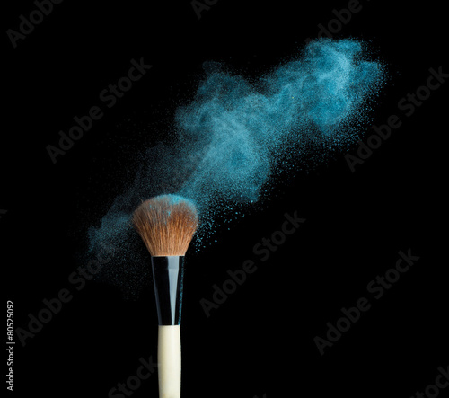 powderbrush on black background with blue powder splash photo