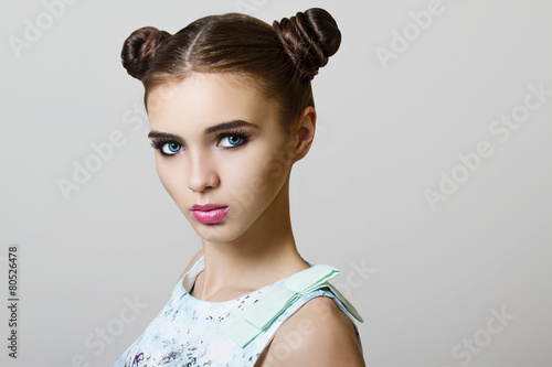 portrait of young woman with makeup and buns