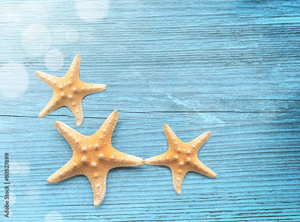 Three starfish on a blue wooden background Three starfish on a blue wooden background