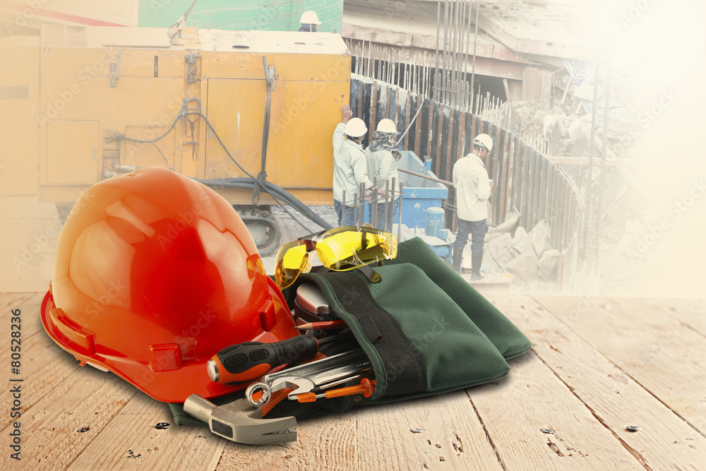 safety helmet and tools on wood table and building construction safety helmet and tools on wood table and building construction