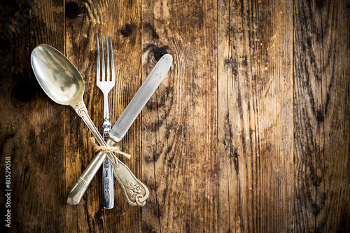 Spoon knife and fork on the wooden board.