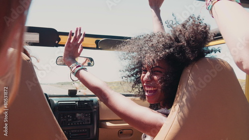 Afro girl laughing with friends on a road trip vacation
