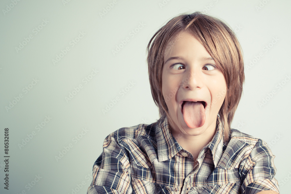 Foto de funny boy with cross-eyed and tongue out - vintage style photo do  Stock
