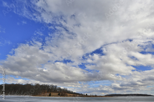 Storm clouds landscape over frozen lake.