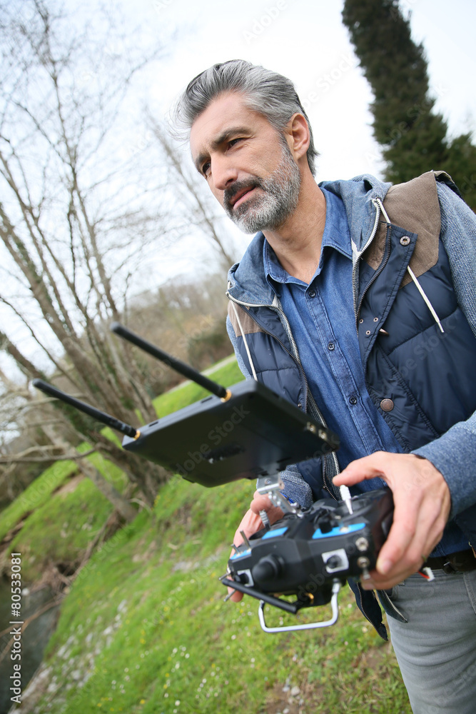 Man operating a drone with remote control