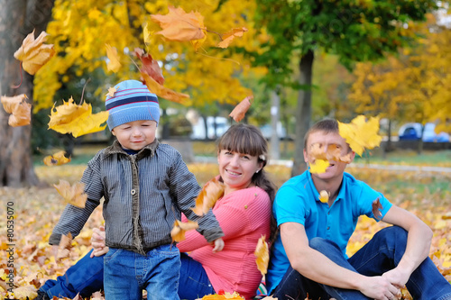 Young family with a child walks in autumn park