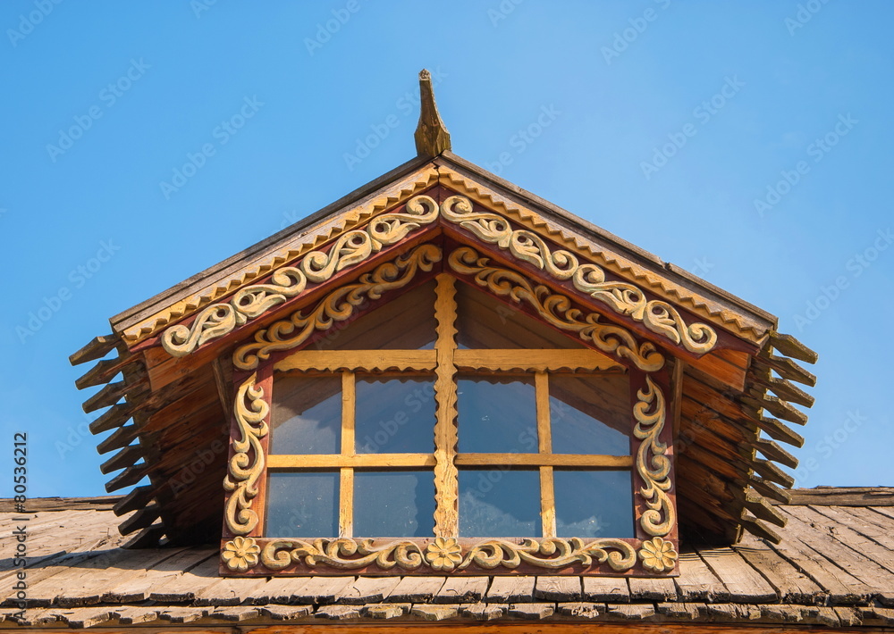 Attic window of  old wooden house decorated with wood carvings