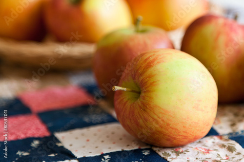 Fresh apples on a vintage quilt of small squares. Close up photo