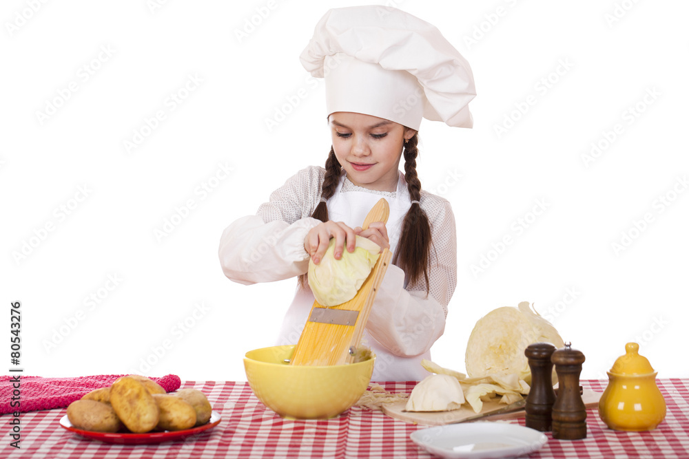 Portrait of a little girl in a white apron and chefs hat shred c Portrait of a little girl in a white apron and chefs hat shred c