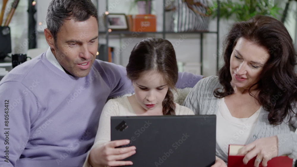 Young girl browsing the internet with her parents Young girl browsing the internet with her parents